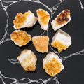 Citrine clusters on a black marble surface
