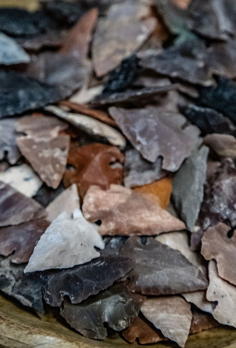 Close-up of handcrafted stone arrowheads with unique shapes and textures, perfect for spiritual rituals, home decor, or historical collections.