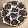  Loose bunches of dried lavender stems wrapped in white tissue paper, arranged inside a cardboard box.