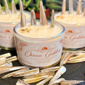 Ocean Goddess coconut soy candle with decorative elements on a dark surface.